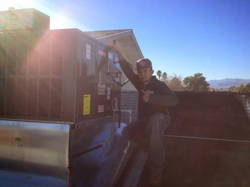 HVAC technician performing Boiler Repair on a rooftop unit in Norwood